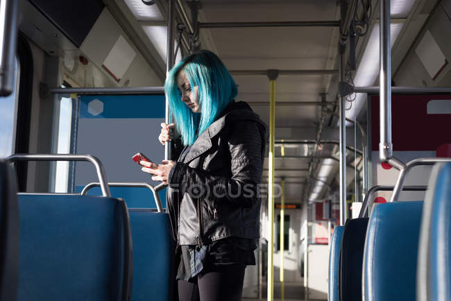 Стильная женщина, пользующаяся мобильным телефоном во время поездки на поезде — стоковое фото