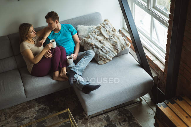 Couple having coffee in living room at home — Stock Photo