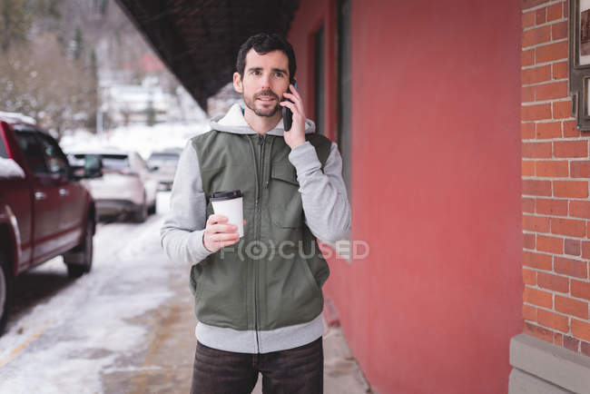 Joven hablando por teléfono móvil fuera de la tienda - foto de stock