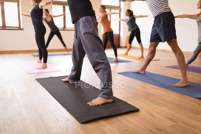 Група людей, які виконують вправи з йоги разом у фітнес-клубі — стокове фото