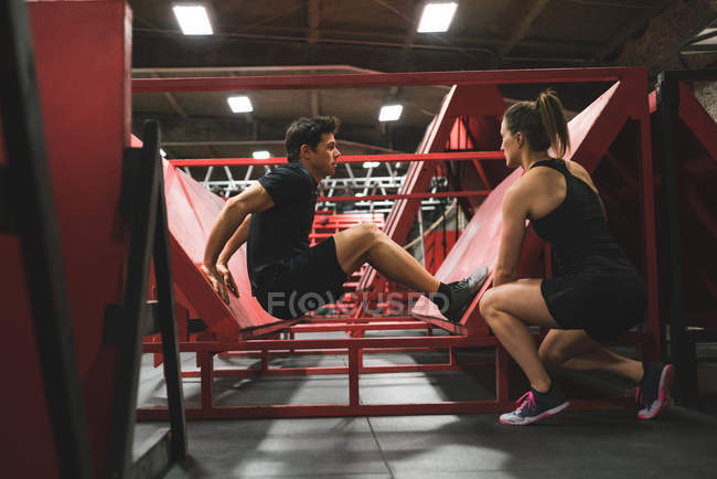Muskulöser Mann übt Liegestütze an schiefer Wand im Fitnessstudio — Stockfoto