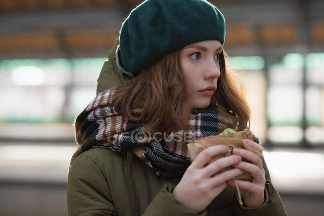 Close-up de mulher em roupas de inverno tendo um envoltório na estação ferroviária — Fotografia de Stock