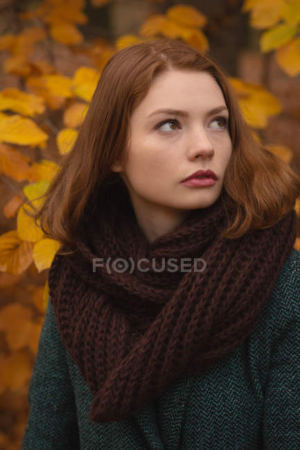 Женщина стоит в парке осенью — стоковое фото
