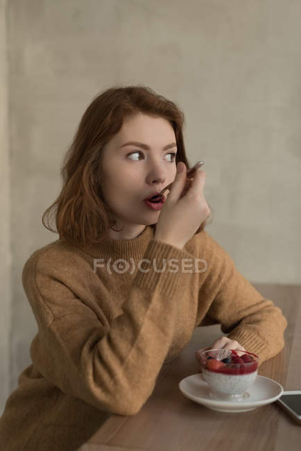 Задумчивая женщина с десертом в кафе — стоковое фото