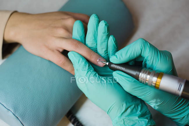 Estetista dando trattamento manicure al cliente femminile in salotto — Foto stock