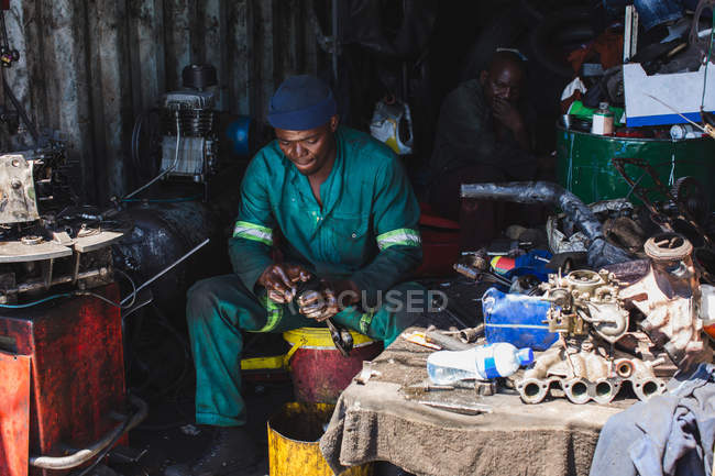 Mechanic repairing auto parts in garage — Stock Photo