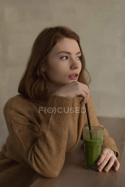 Thoughtful woman having health shake drink in cafe — Stock Photo