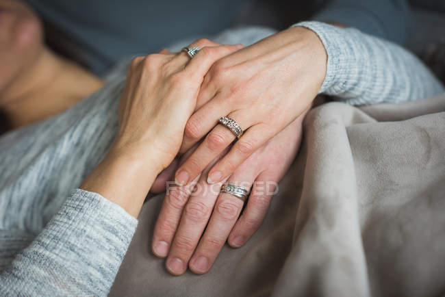 Пара тримає руки у вітальні вдома — стокове фото