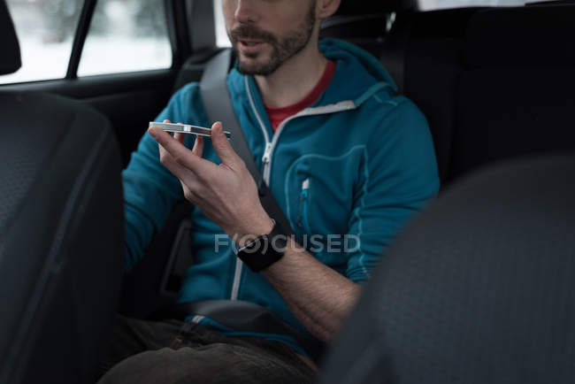 Partie médiane de l'homme parlant sur un téléphone portable dans une voiture — Photo de stock