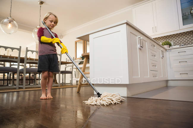 Junge wäscht den Boden zu Hause mit Wischmopp — Stockfoto