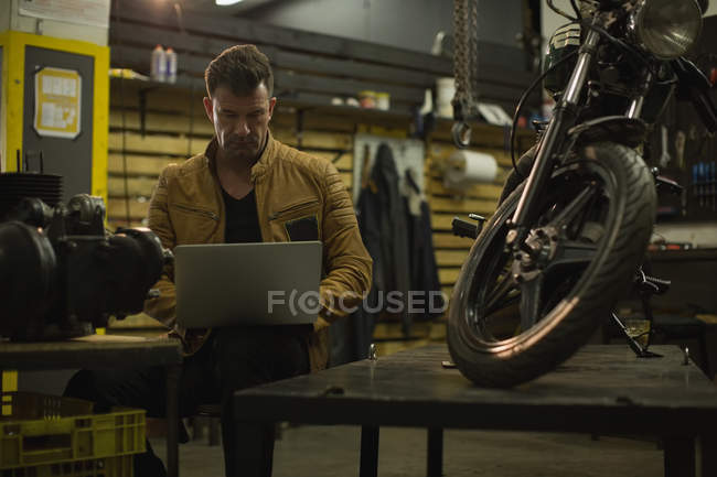 Механічний за допомогою ноутбука в гаражі — стокове фото