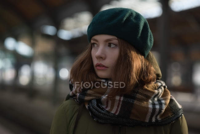 Close-up de mulher em roupas de inverno em pé na estação ferroviária — Fotografia de Stock