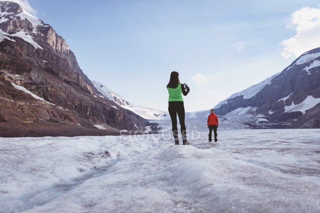 Жінка фотографує мобільний телефон на сніжному пейзажі — стокове фото