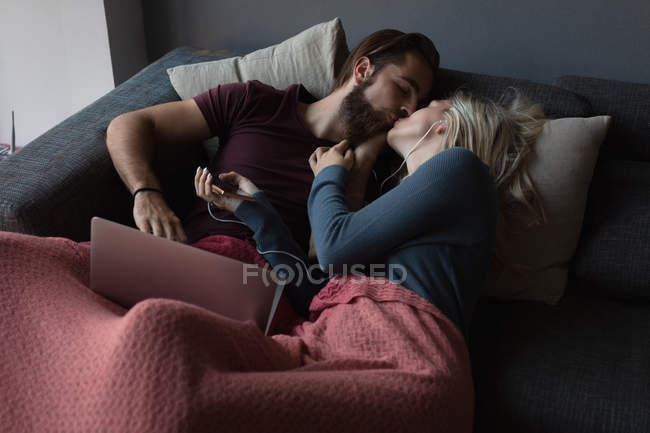 Paar küsst sich im Wohnzimmer zu Hause — Stockfoto