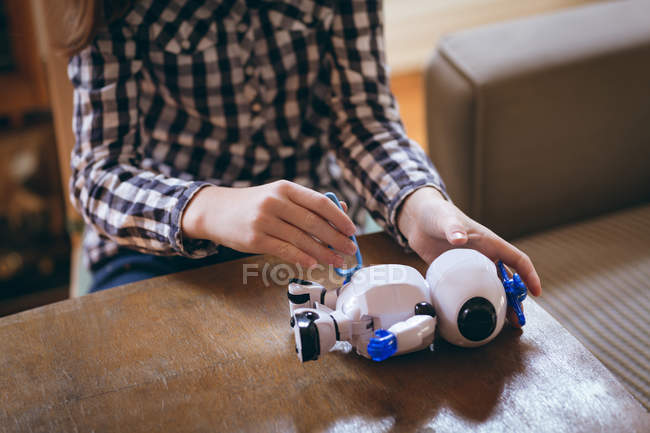 Sezione centrale della ragazza che fissa il giocattolo robotico a casa — Foto stock