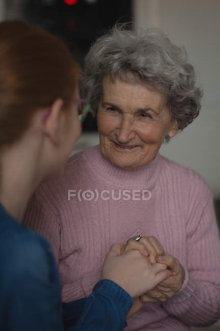 Бабушка и внучка общаются на кухне дома — стоковое фото