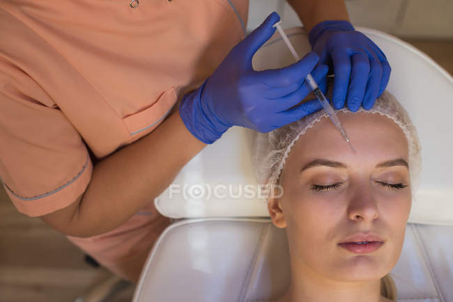 Beautician giving beauty treatment to female customer in parlour — Stock Photo