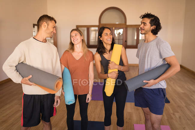 Groupe d'amis interagissant les uns avec les autres dans le club de fitness — Photo de stock