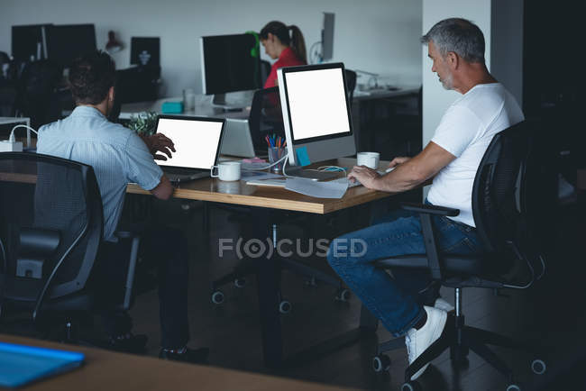Compañeros de negocios trabajando en el escritorio en la oficina - foto de stock