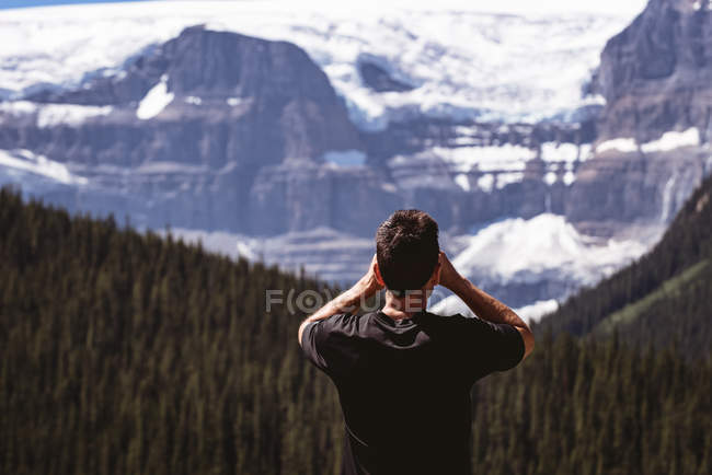 Вид ззаду людини, що дивиться на засніжені гори — стокове фото