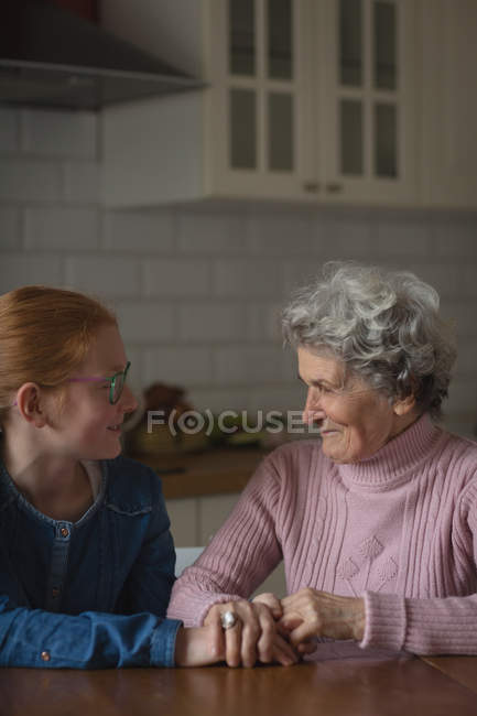 Бабуся і онука взаємодіють один з одним на кухні вдома — стокове фото