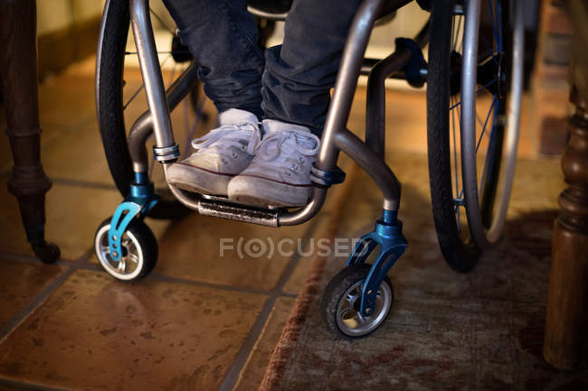 Bassa sezione di uomo disabile in sedia a rotelle a casa — Foto stock