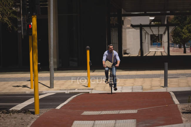 Man riding bicycle on street on a sunny day — Stock Photo