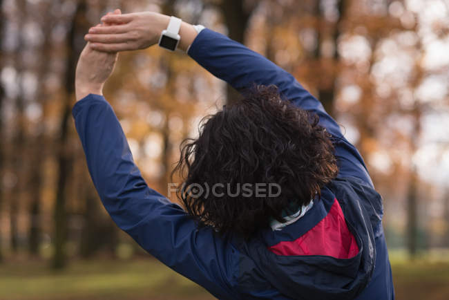 Rear view of woman performing stretching exercise in the park — Stock Photo