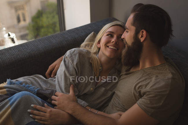Пара обіймає один одного у вітальні вдома — стокове фото