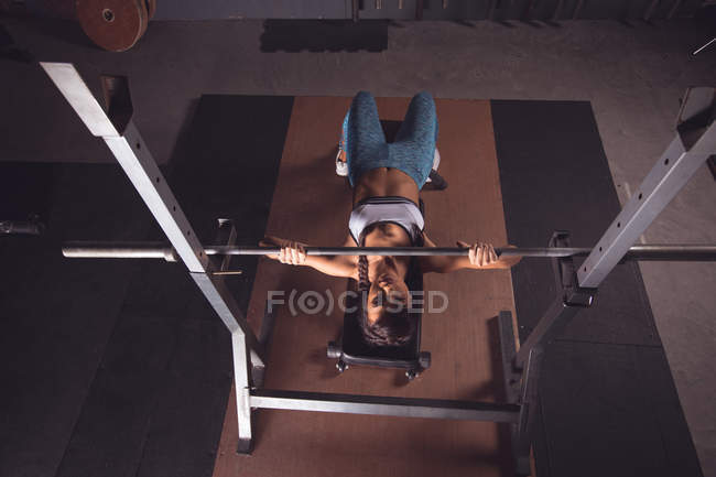 Ajuste mujer levantando la barra de barra en el gimnasio - foto de stock