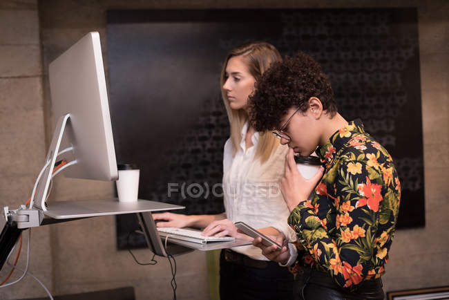 Ejecutivas que trabajan en la computadora en la oficina - foto de stock