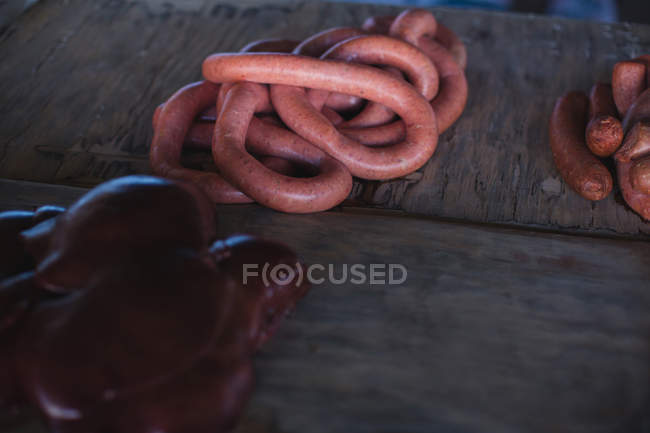 Salsicha e carnes à mesa no talho — Fotografia de Stock