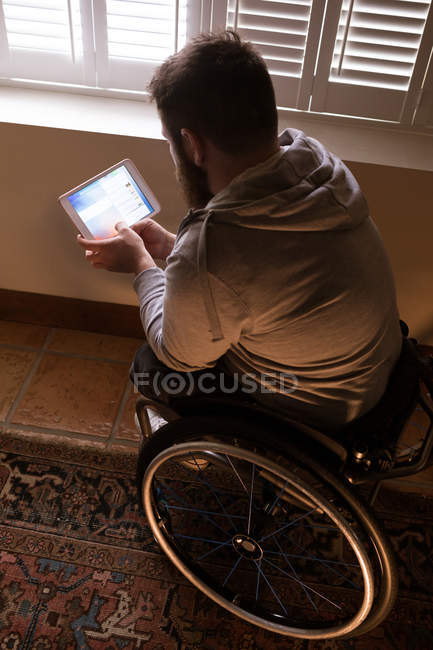 Homem com deficiência usando tablet digital em casa — Fotografia de Stock