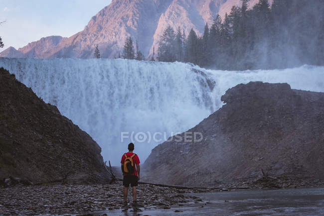 Vue arrière de l'homme regardant la cascade — Photo de stock