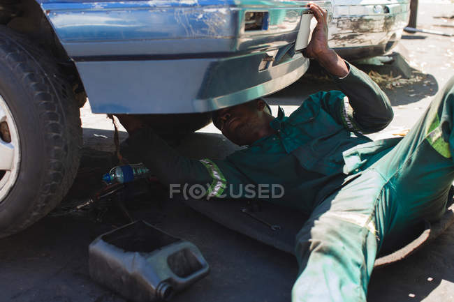 Mechanic repairing a car in garge — Stock Photo