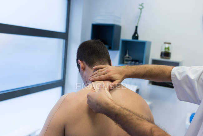 Physiotherapist applying bandage on patients back in clinic — Stock Photo
