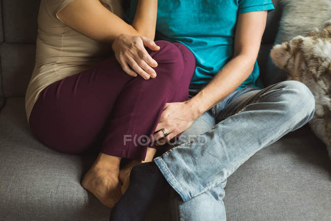 Coppia seduta insieme sul divano in soggiorno a casa — Foto stock