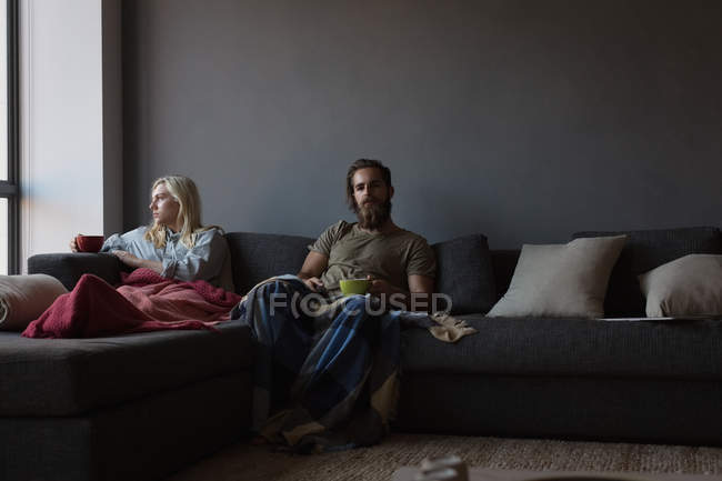 Пара ігнорує один одного у вітальні вдома — стокове фото