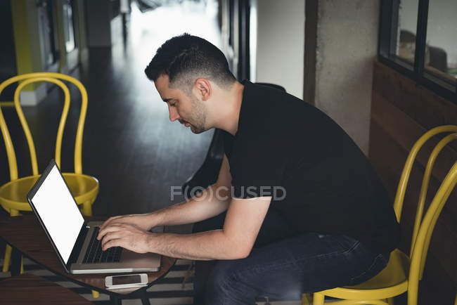 Бізнесмен використовує ноутбук в кафетерії в офісі — стокове фото