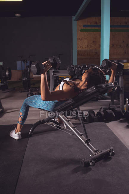 Fitte Frau trainiert mit Kurzhanteln im Fitnessstudio — Stockfoto