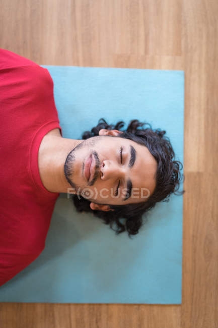 Joven meditando en el gimnasio - foto de stock