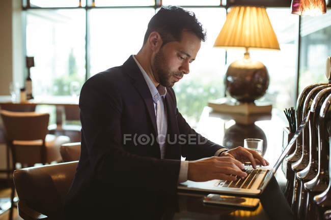 Бізнесмен використовує ноутбук біля лічильника в готелі — стокове фото