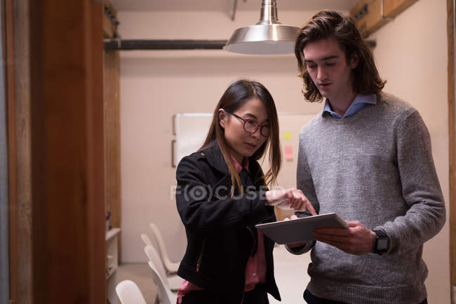 Business colleagues discussing over digital tablet in office — Stock Photo