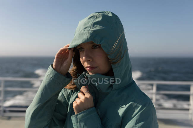Beautiful woman in hoodie standing on cruise ship — Stock Photo