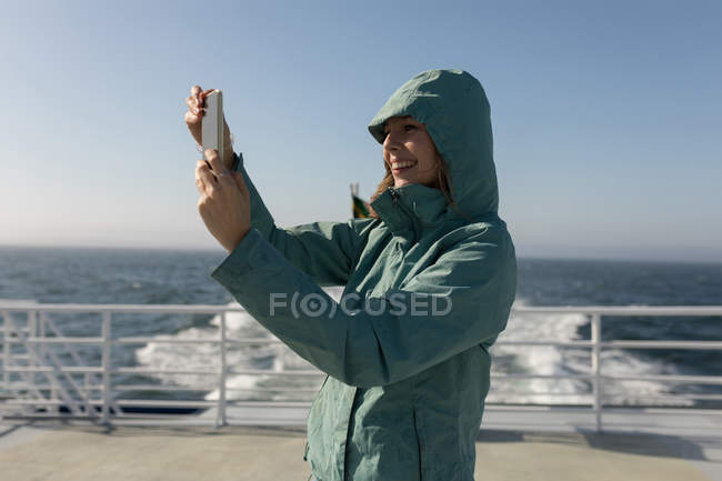 Mulher tomando selfie com telefone celular em navio de cruzeiro — Fotografia de Stock