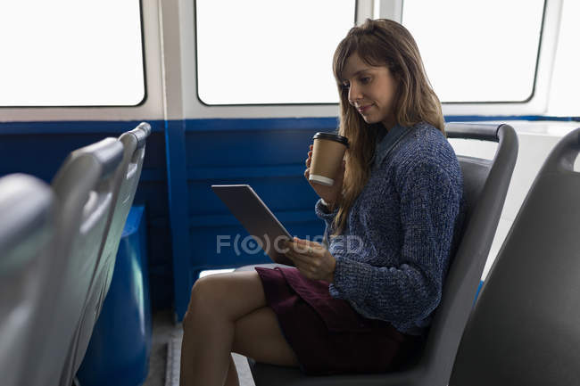 Красива жінка використовує цифровий планшет, маючи каву в круїзному кораблі — стокове фото