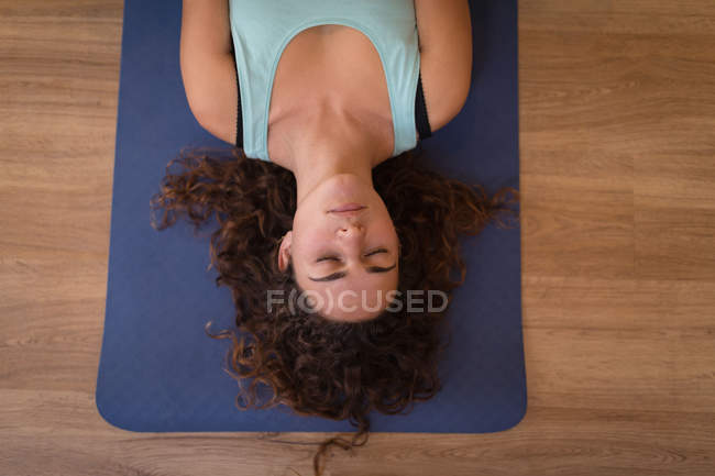 Молодая женщина медитирует в фитнес-клубе — стоковое фото