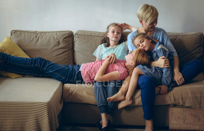 Мать и дети отдыхают на диване в гостиной — стоковое фото