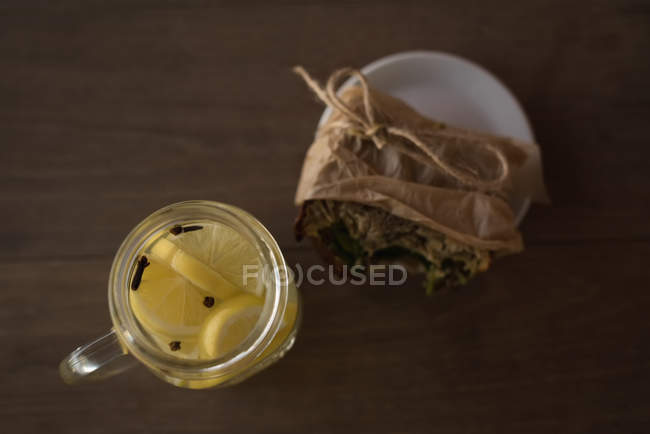 Накладные расходы на банку лимонного чая с оберточной пищей на тарелке в кафе — стоковое фото