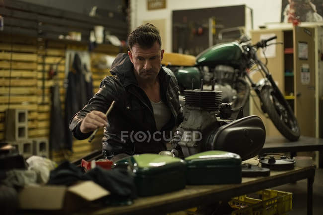 Mechanic repairing motorbike in garage — Stock Photo